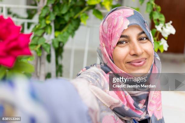 muslim woman sitting in backyard making selfie with phone - turkey middle east stockfoto's en -beelden