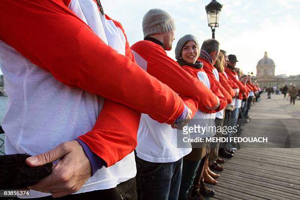 Des bénévoles de l'association Sidaction font une chaîne humaine de solidarité, le 29 novembre 2008 sur le pont des Arts à Paris, à l'occasion de la...