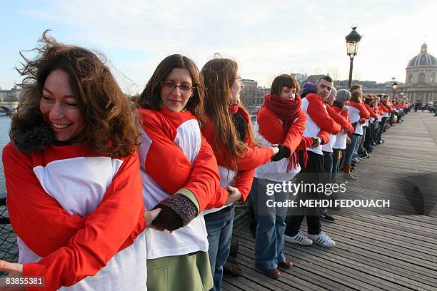 Des bénévoles de l'association Sidaction font une chaîne humaine de solidarité, le 29 novembre 2008 sur le pont des Arts à Paris, à l'occasion de la...