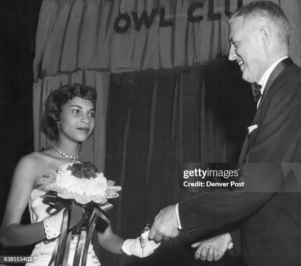 Mayor Will F. Nicholson presents a gift to Miss Sandra Clark, senior at North high school, during debutantes' ball over which he presided Friday...