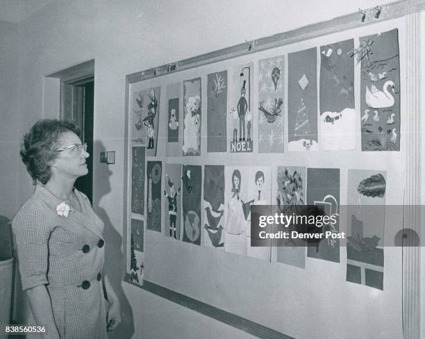 Mrs. Pat Brown, 1731 Kearney St., art teacher at West Junior High School, looks over miniatures of door decorations that were models for full-size...
