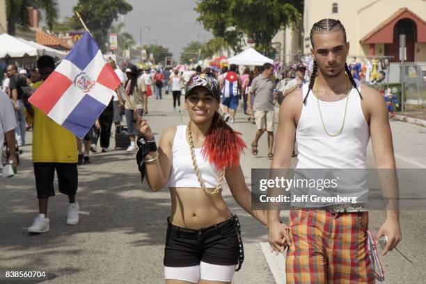 Couple holding a Dominican Republic flag at Carnival Miami.