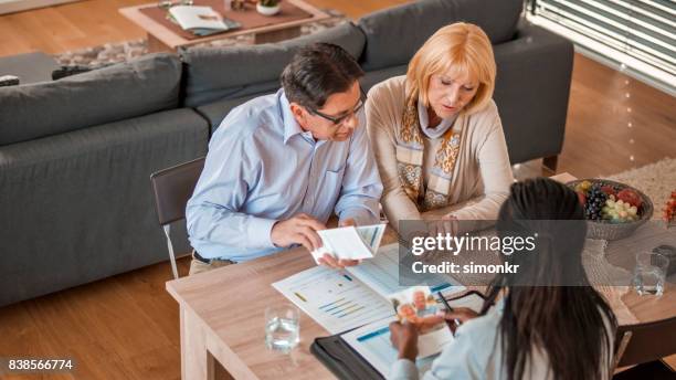 verzekeringsagent bespreken met paar - investment brochures stockfoto's en -beelden