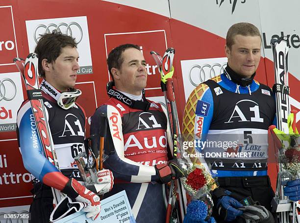 Winners listen to the Italian national anthem as they celebrate their victories in the FIS Ski World Cup men's downhill November 29, 2008 in Lake...