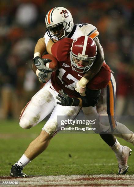 Tight end Brad Smelley of the Alabama Crimson Tide is brought down by safety Zac Etheridge of the Auburn Tigers at Bryant-Denny Stadium on November...