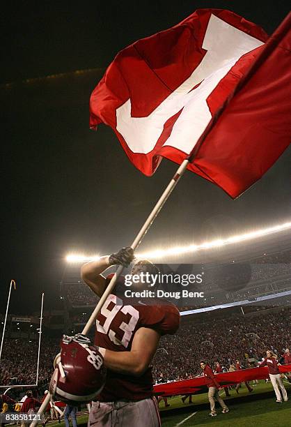 Defensive lineman Bobby Greenwood of the Alabama Crimson Tide waves an Alabama flag after defeating the Auburn Tigers at Bryant-Denny Stadium on...