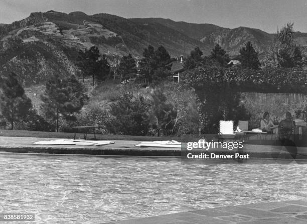 Seen from across the pool of the luxurious Garden of the Gods Club at Colorado Springs is the marred mountainside where the Castle Concrete Co. Is...