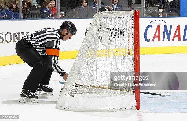 Referee Dan Marouelli tries to remove a stick from the net as the Toronto Maple Leafs face the Philadelphia Flyers during their NHL game at the Air...