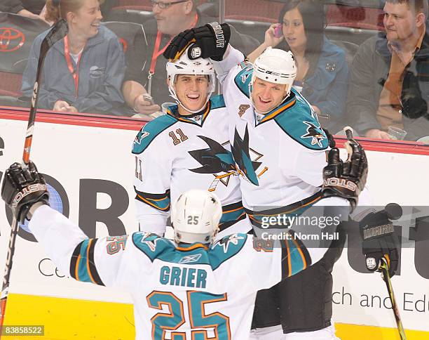 Mike Grier celebrates with teammates Rob Blake and Marcel Goc of the San Jose Sharks after Blake scored to tie the game against the Phoenix Coyotes...