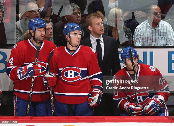 Injured player Mike Komisarek of the Montreal Canadiens takes on a role of assistant coach behind the bench for a game against the Buffalo Sabres at...