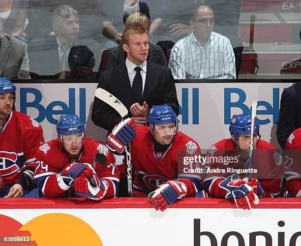 Injured player Mike Komisarek of the Montreal Canadiens takes on a role of assistant coach behind the bench for a game against the Buffalo Sabres at...