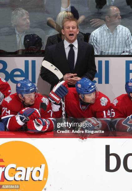 Injured player Mike Komisarek of the Montreal Canadiens yells some orders as he takes on a role of assistant coach behind the bench for a game...