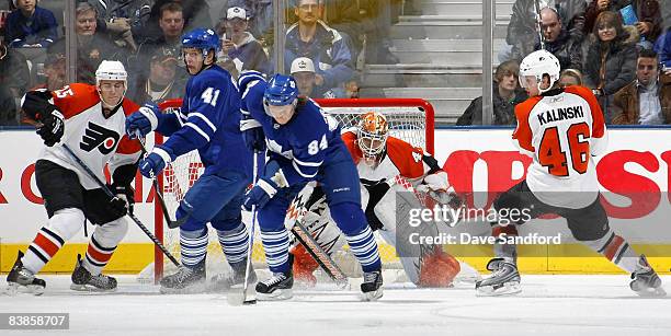 Mikhail Grabovski of the Toronto Maple Leafs carries the puck as teammate Nikolai Kulemin battles in front of Martin Biron of the Philadelphia Flyers...