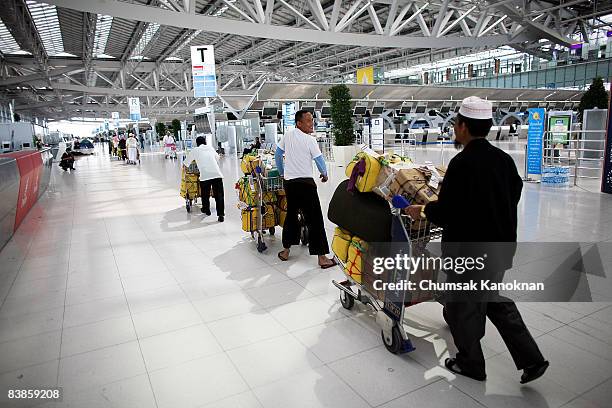 Thai muslim pilgrims walk with their lugguage at Suvarnabhumi airport on November 30, 2008 in Bangkok, Thailand. Nearly 100,000 passengers have...