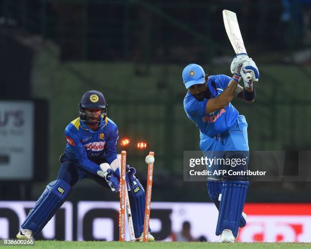 India's captain Virat Kohli is dismissed as Sri Lanka's wicketkeeper Niroshan Dickwella looks on during the second One Day International cricket...