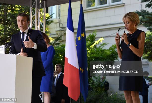 French President Emmanuel Macron speaks next to his wife Brigitte Macron during a meeting with members of the French business community at the French...
