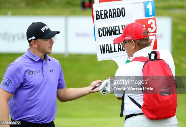 Matt Wallace of England gives a signed glove to the marshall who found his ball on the 18th hole during day one of Made in Denmark at Himmerland Golf...