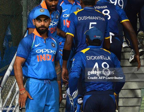 India's captain Virat Kohli reacts as he greets Sri Lanka's players after India's victory in the second one day international cricket match between...