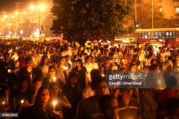Mumbai Residents walk with candles in the street near The Oberoi Hotel during a demonstration against the recent terror attacks in the city on...