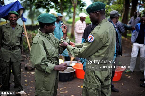 Park ranger helps another one with his new uniform at the park's headquarters of the Virunga National Park, on November 28, 2008 in Rumangabo. The...