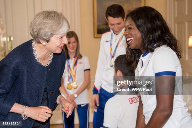 British Prime Minister Theresa May speaks to Asha Philip who won silver in the 4x100m during a a reception for who competed in the World Athletics...