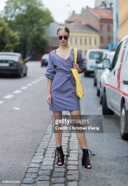 Model Lea Meyer wearing a plaid dress, yellow bag, black sandals outside Vanessa Rudjord on August 24, 2017 in Oslo, Norway.