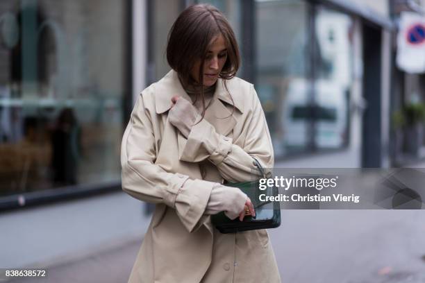 Darja Barannik wearing a trench coat, red boots, green bag outside Bik Bok Runway Award on August 24, 2017 in Oslo, Norway.