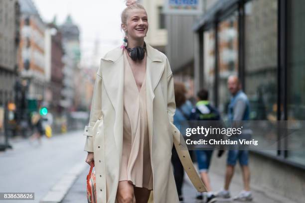 Marianne Theodorsen wearing a trench coat, pastel dress, boots and Balenciaga bag outside Bik Bok Runway Award on August 24, 2017 in Oslo, Norway.