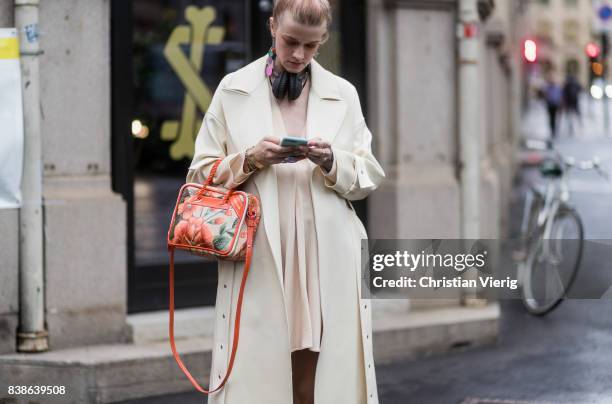 Marianne Theodorsen wearing a trench coat, pastel dress, boots and Balenciaga bag outside Bik Bok Runway Award on August 24, 2017 in Oslo, Norway.