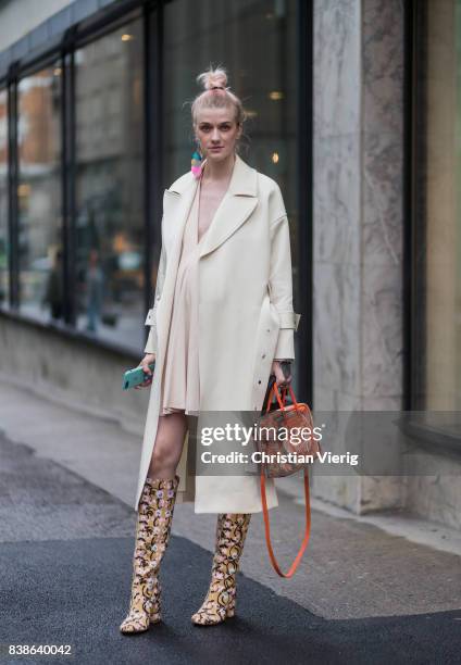 Marianne Theodorsen wearing a trench coat, pastel dress, boots and Balenciaga bag outside Bik Bok Runway Award on August 24, 2017 in Oslo, Norway.