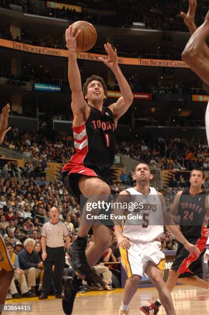 Roko Ukic of the Toronto Raptors goes up for a shot while Jordan Farmar of the Los Angeles Lakers looks on at Staples Center on November 30, 2008 in...