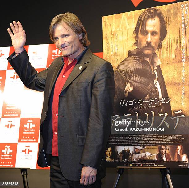 Actor Viggo Mortensen waves to the media during a photo session after a news conference to promote his latest film "Alatriste" in Tokyo on December...