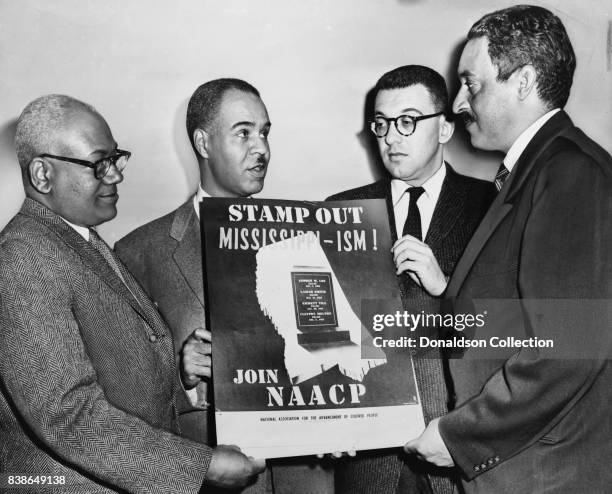 Holding a poster against racial bias in Mississippi are four of the most active leaders in the NAACP movement, from left: Henry L. Moon, director of...