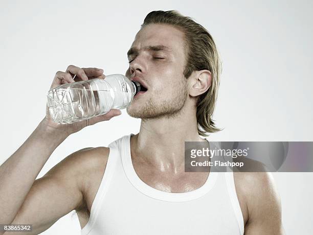 portrait of man drinking water - tank top stock pictures, royalty-free photos & images