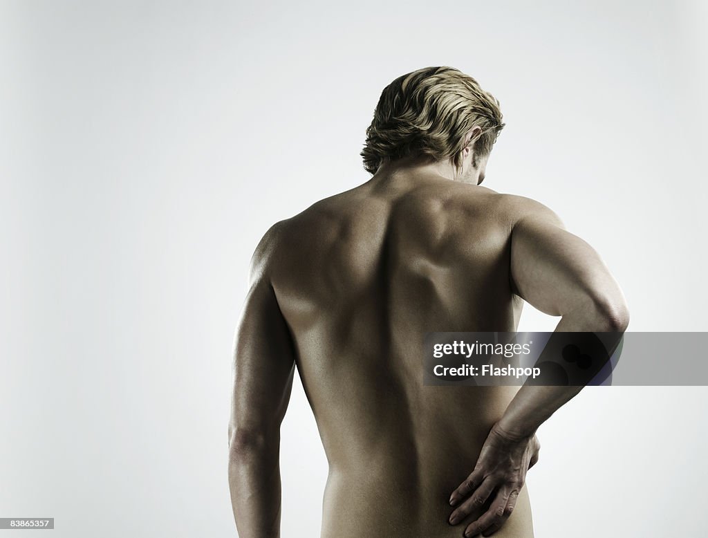 Portrait of man touching his back