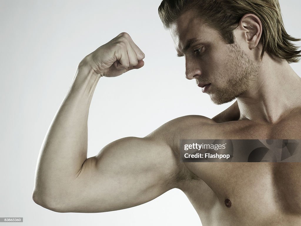 Portrait of man flexing arm muscles