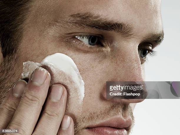 close-up portrait of man applying moisturizer - 都會型男 個照片及圖片檔