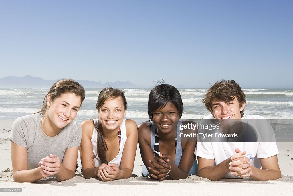 Group of friends lying on beach 