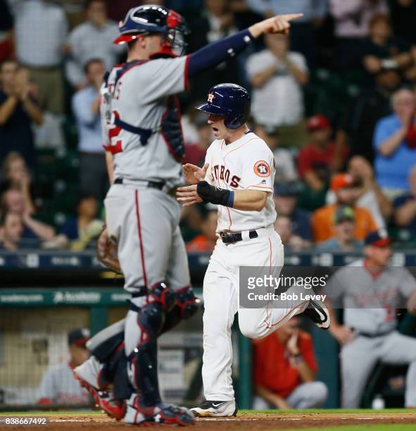 Alex Bregman of the Houston Astros scores on a single off the bat of Josh Reddick of the Houston Astros in the ninth inning as Matt Wieters of the...
