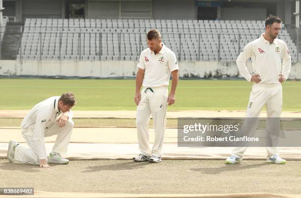 Steve Smith, David Warner and Glenn Maxwell of Australia check the pitch before an Australian Test team nets session at Sher-E Bangla National...