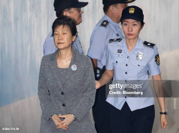 Park Geun-hye, former president of South Korea, left, is escorted by a prison officer as she arrives at the Seoul Central District Court in Seoul,...