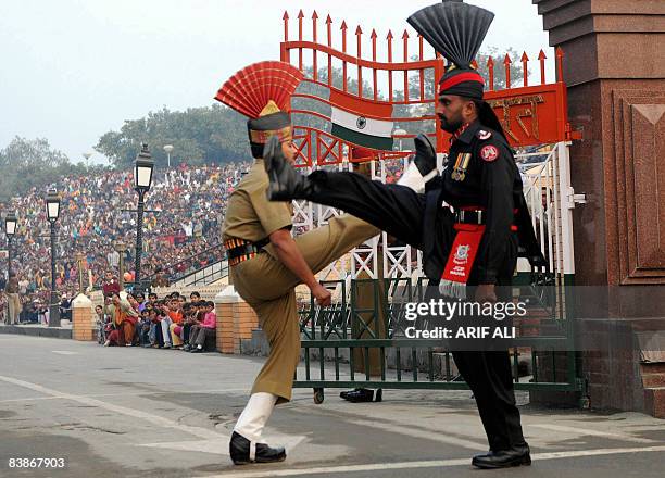 Pakistani Ranger and an Indian Border Security Force Jawan march during the flag-lowering ceremony at the Wagah border on December 1, 2008. India's...