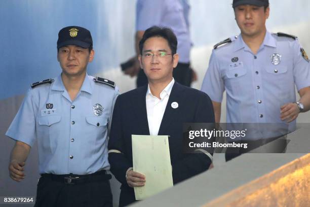 Jay Y. Lee, co-vice chairman of Samsung Electronics Co., center, is escorted by prison officers as he arrives at the Seoul Central District Court in...