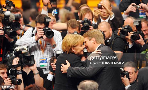 Photographers take pictures of German Chancellor Angela Merkel embracing CDU General Secretary Ronald Pofalla after she was re-elected as the party...