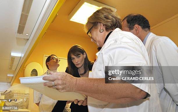 French President Nicolas Sarkozy's wife Carla Bruni Sarkozy talks with the medical staff of the Saint-Louis Hospital in Paris during a visit of a...