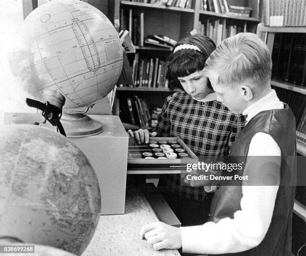 Leslie Blush and Douglas Eisele pick out their film from the tray. Material on the film strips, ranging from astrology to Zoology, is shown on a...