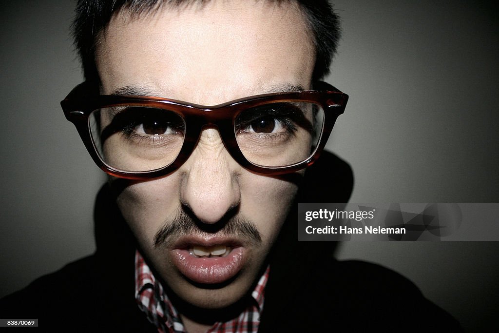 Portrait of a snarling face with thick glasses