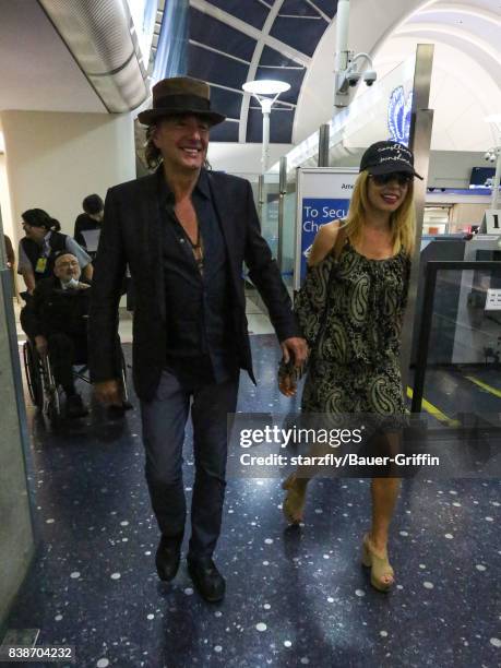 Richie Sambora and Orianthi Panagaris are seen at Los Angeles International Airport on August 24, 2017 in Los Angeles, California.