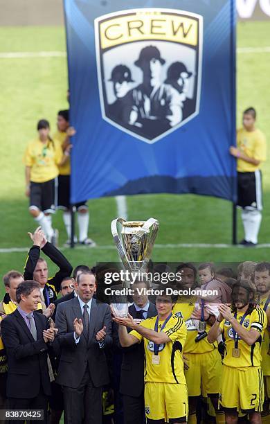 Guillermo Barros Schelotto of the Columbus Crew pose holds up the game MVP trophy on the podium after defeating the New York Red Bulls 3-1 in the...