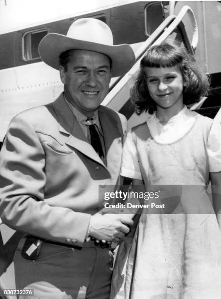 Kirby Grant, the "Sky King" of television fame, is greeted at Stapleton airfield by Patty Martell a Chicago youngster who is visiting her...